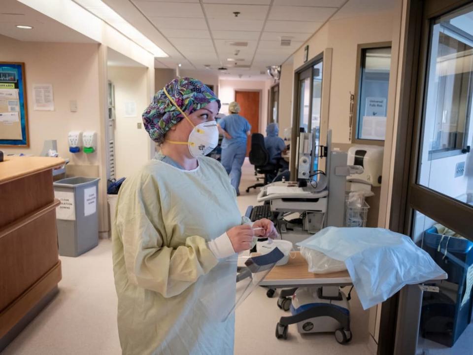 A nurse wearing personal protective equipment prepares to enter a patient’s room in the intensive care unit at North York General Hospital on May 26, 2020. Researchers at the University of Windsor are developing a course to help prepare nursing graduates for extreme stress in hospital settings.  (Evan Mitsui/CBC - image credit)