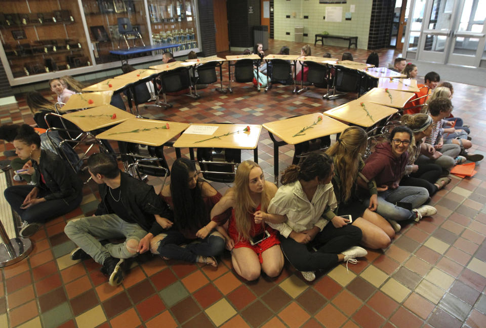 Students link arms around 17 desks, one for each of those killed during the Parkland, Florida, shooting, during a walkout demonstration Wednesday, March 14, 2018, at Cheyenne’s East High to protest the shooting deaths of students at schools across the United States. (Jacob Byk/The Wyoming Tribune Eagle via AP)