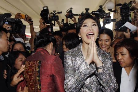 Ousted former Prime Minister Yingluck Shinawatra greets in a traditional way as she leave Parliament after delivering a statement during the National Legislative Assembly meeting in Bangkok January 22, 2015. REUTERS/Chaiwat Subprasom