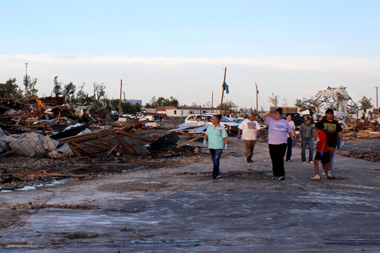 People survey the damage as cleanup efforts continue on Friday in Perryton, Texas (AP)
