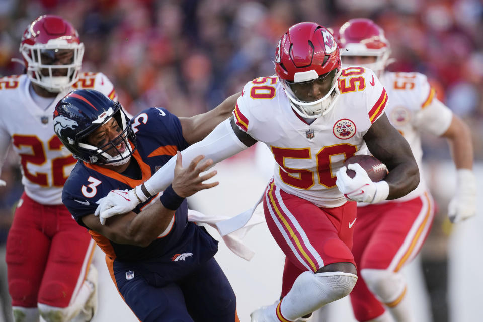 Kansas City Chiefs linebacker Willie Gay, right, runs past Denver Broncos quarterback Russell Wilson (3) to score a touchdown after intercepting a Wilson pass during the first half of an NFL football game Sunday, Dec. 11, 2022, in Denver. (AP Photo/David Zalubowski)