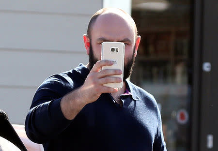 Simon Dowson is pictured holding up a smartphone as he walks to his car in Consett, Britain, September 30, 2016. REUTERS/Scott Heppell