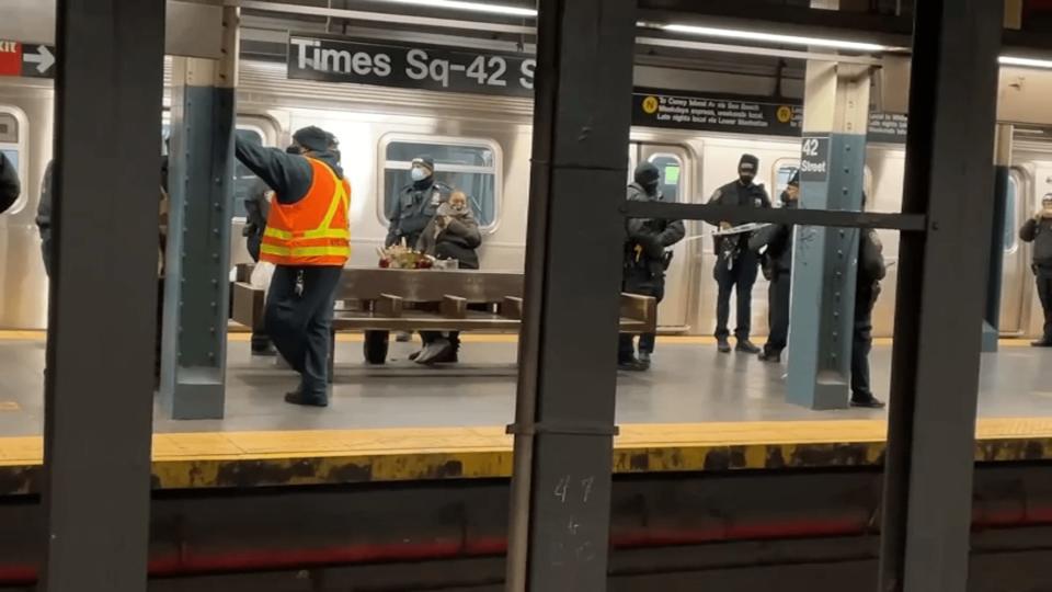 Police and transit crew members investigate a deadly assault on a Times Square subway platform. (NBC New York)