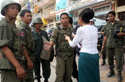 Kek Galabru (2nd R-back to camera), president of LICADHO -- a Cambodian human rights NGO -- seen here speaking to policemen in Phnom Penh, in 2006, as rights activists marked the first anniversary of the trial of two men convicted of killing popular union leader Chea Vichea