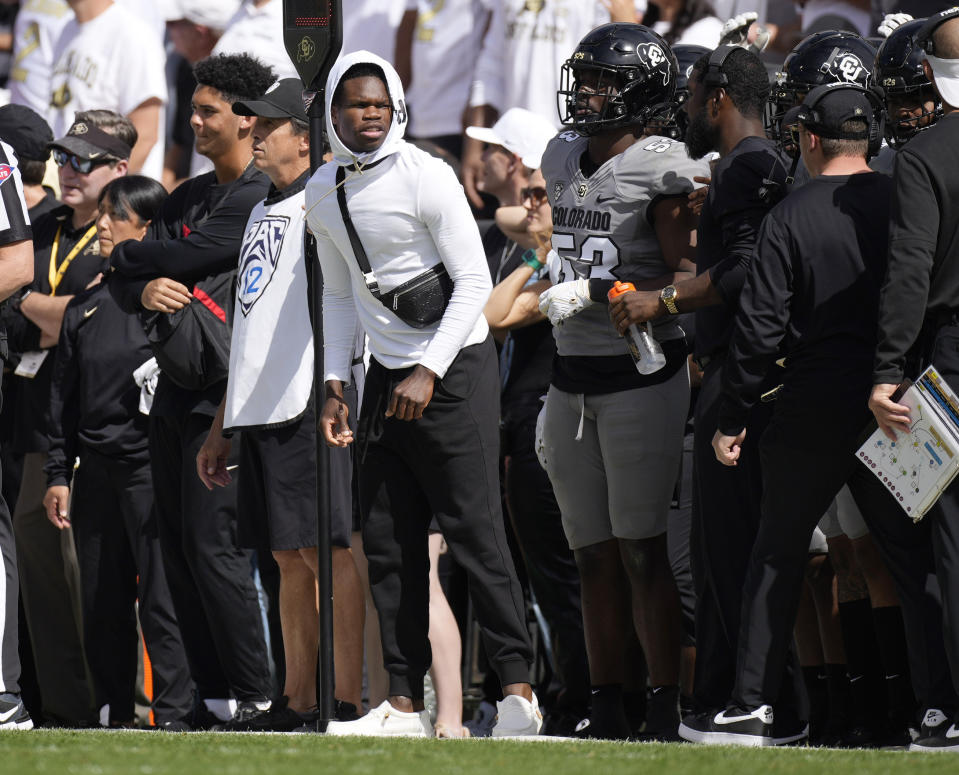 Injured Colorado defensive back Travis Hunter, center, looks on from the sideline in the second half of an NCAA college football game against Southern California, Saturday, Sept. 30, 2023, in Boulder, Colo. (AP Photo/David Zalubowski)