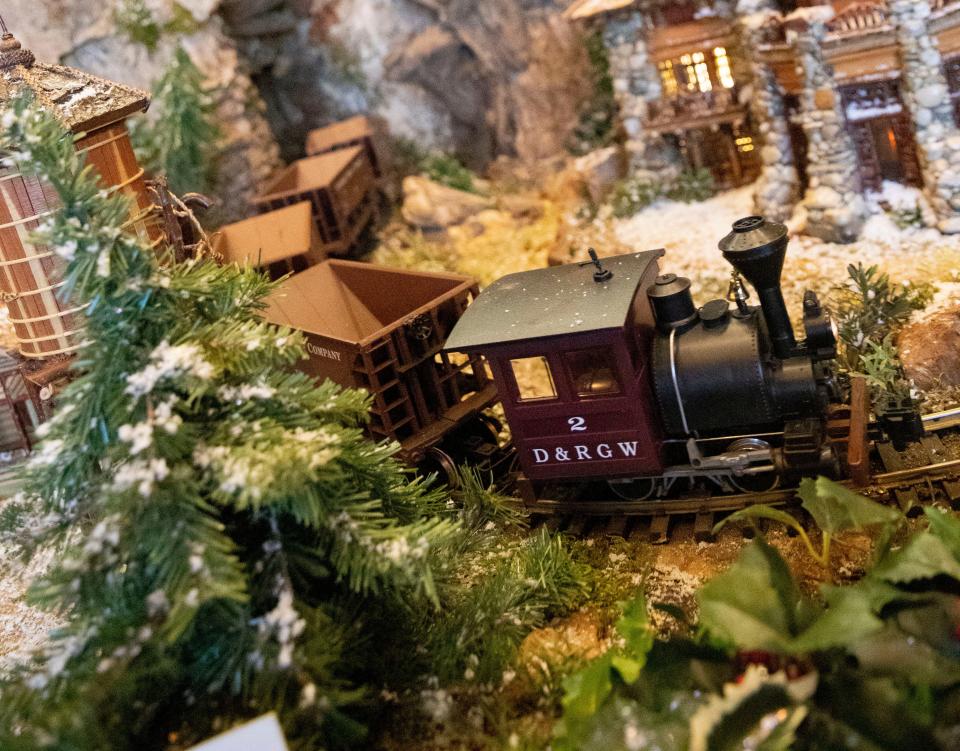 A model train passes through in the Jingle Rails exhibit Tuesday, Nov. 30, 2021, at the Eiteljorg Museum of American Indians and Western Art in Indianapolis. The museum is undergoing renovations to its Native American galleries for the first time since it opened in 1989. As part of these renovations, the space Jingle Rails is held will be expanded.