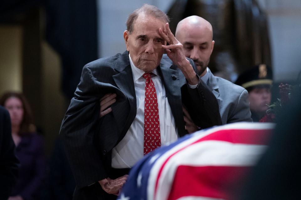 Former Sen. Bob Dole salutes before the flag-draped coffin.