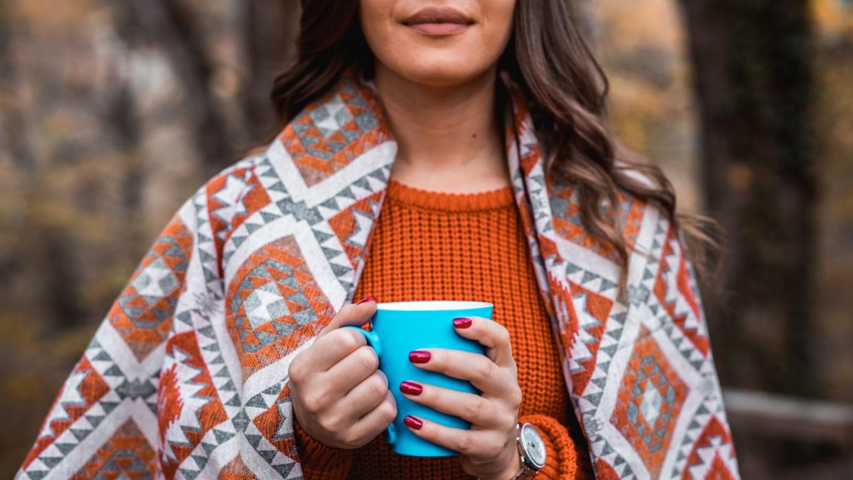 woman in autumn colors holding coffee mug