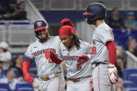Washington Nationals' Luis Garcia Jr., left, congratulates CJ Abrams (5) and Trey Lipscomb (38) after Abrams and Lipscomb scored on a single by Joey Meneses during the eighth inning of a baseball game against the Miami Marlins, Friday, April 26, 2024, in Miami. (AP Photo/Wilfredo Lee)