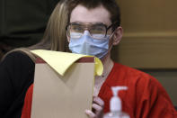 Marjory Stoneman Douglas High School shooter Nikolas Cruz flips the pages of his tablet back after writing in it during a hearing at the Broward County Courthouse in Fort Lauderdale, Fla. on Monday, Jan. 24, 2022. (Amy Beth Bennett/South Florida Sun Sentinel via AP, Pool)