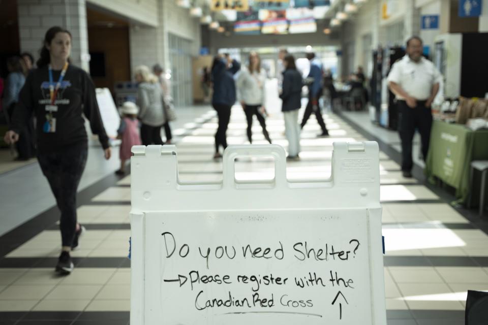 A sign directing evacuees is seen as volunteers and workers set up an evacuation centre where food and shelter is being provided for those forced from their homes due to the wildfire burning in suburban Halifax, Nova Scotia, on Tuesday, May 30, 2023. (Darren Calabrese/The Canadian Press via AP)