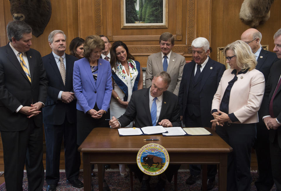 FILE - In this March 29, 2017, file photo, Interior Secretary Ryan Zinke, accompanied by Republican members of Congress, signs an order lifting a moratorium on new coal leases on federal lands and a related order on coal royalties, at the Interior Department in Washington. From left are Sen. Steve Daines, R-Mont., Sen. John Hoeven, R-N.D., Sen. Lisa Murkowski, R-Alaska, Zinke's wife Lolita, Rep. Scott Tipton, R-Colo., Rep. Rob Bishop, R-Utah and Rep. Liz Cheney, R-Wyo. The Trump administration is considering using West Coast military bases or other federal properties as transit points for shipments of U.S. coal and natural gas to Asia as officials seek to bolster the domestic energy industry and circumvent environmental opposition to fossil fuel exports, according to Zinke and two Republican lawmakers. (AP Photo/Molly Riley, File)