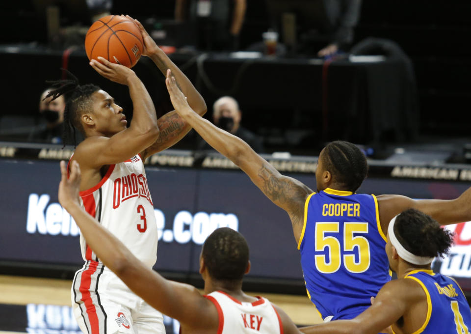 Ohio State guard Eugene Brown, left, goes up for a shot against Morehead State guard Ta'lon Cooper (55) during the first half of an NCAA college basketball game in Columbus, Ohio, Wednesday, Dec. 2, 2020. (AP Photo/Paul Vernon)