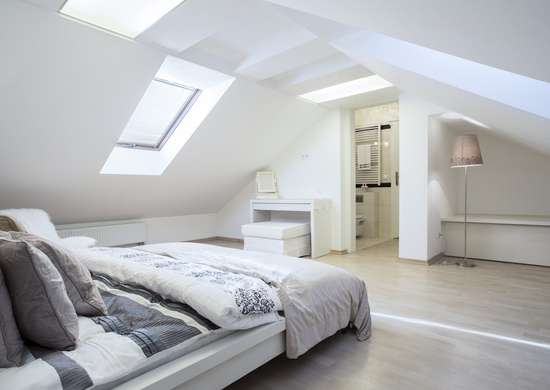 Spacious bedroom with sloped ceiling.