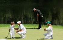 <p>Jason Day of Australia waits on a green with his son Dash as Erik Compton of the United States looks on during the Par 3 Contest prior to the start of the 2015 Masters Tournament at Augusta National Golf Club on April 8, 2015 in Augusta, Georgia. (Photo by Jamie Squire/Getty Images) </p>