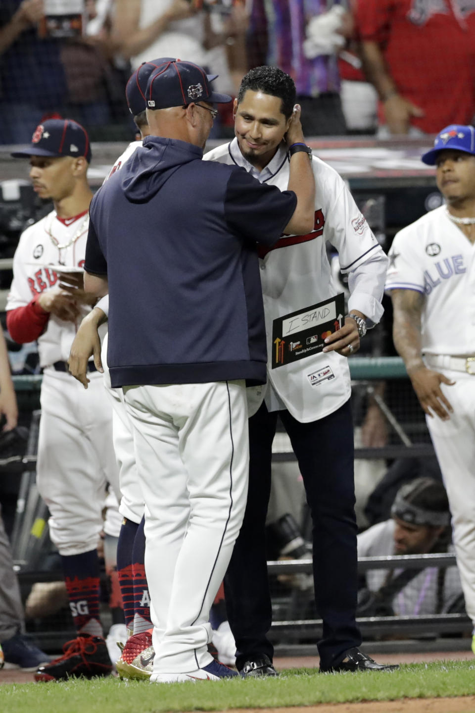 Cleveland Indians manager Terry Francona, left, hugs Indians pitcher Carlos Carrasco during the middle of the fifth inning of the MLB baseball All-Star Game, Tuesday, July 9, 2019, in Cleveland. The Indians' right-hander, who was recently diagnosed with a form of leukemia, was saluted in the fifth inning of the game as part of Major League Baseball's "Stand Up to Cancer" campaign. (AP Photo/Tony Dejak)