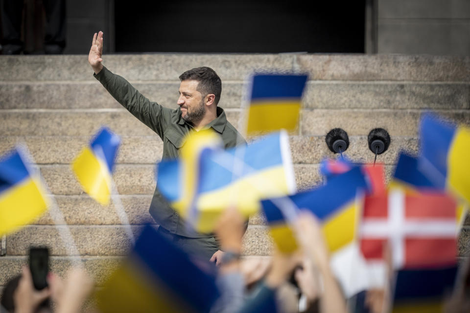 Ukrainian President Volodymyr Zelenskyy greets the Danish people after speaking from the steps of Christiansborg palace, the seat of Danish Parliament, in Copenhagen, Denmark, Monday, Aug. 21, 2023. Thousands of people had gathered in the palace courtyard to hear his speech, many waving Ukrainian or Danish flags. (Mads Claus Rasmussen/Ritzau Scanpix via AP)