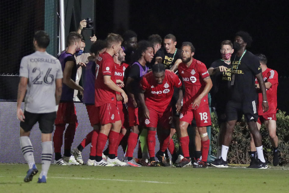 Ayo Akinola (centro) festeja con sus compañeros del Toronto FC luego de anotar su tercer gol del encuentro ante el Impact de Montreal, el jueves 16 de julio de 2020, en Kissimmee, Florida (AP Foto/John Raoux)