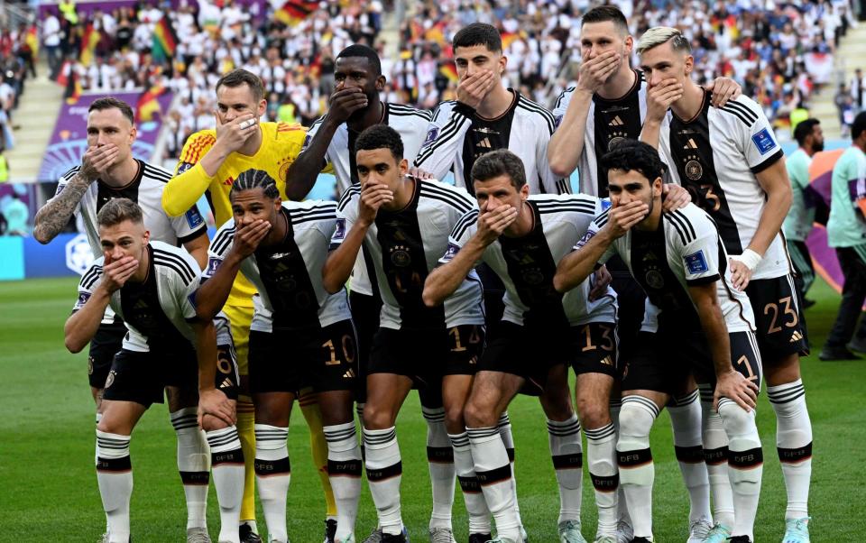 German players covered their mouths as they posed for a team photo ahead of kick-off - Ina Fassbender/AFP