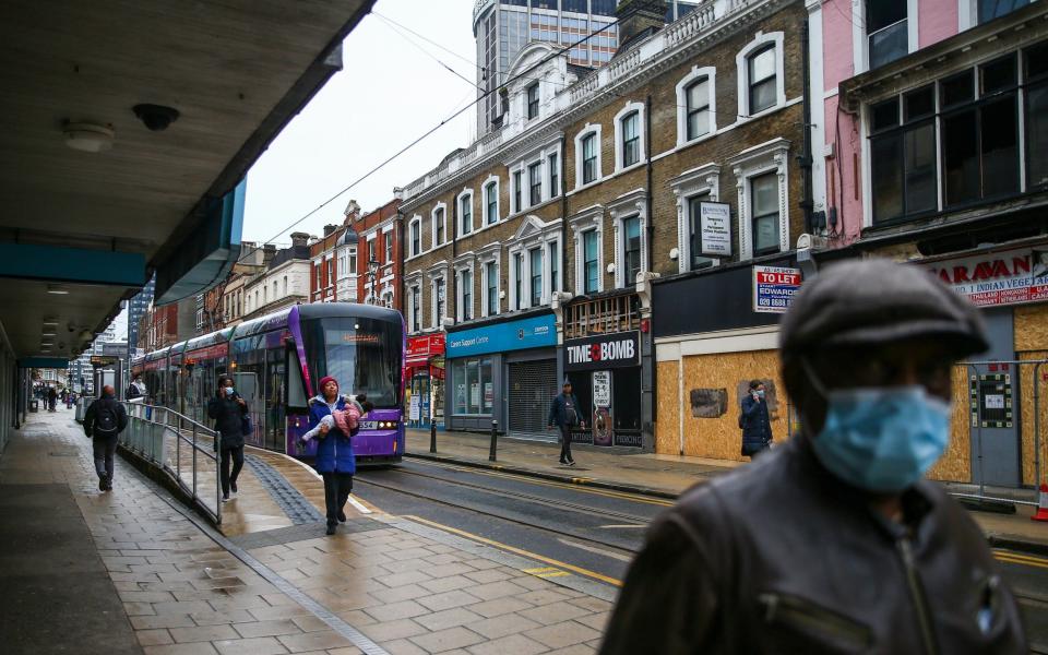 Pedestrians walk past boarded up shops on George Street in Croydon -  Hollie Adams/ Bloomberg