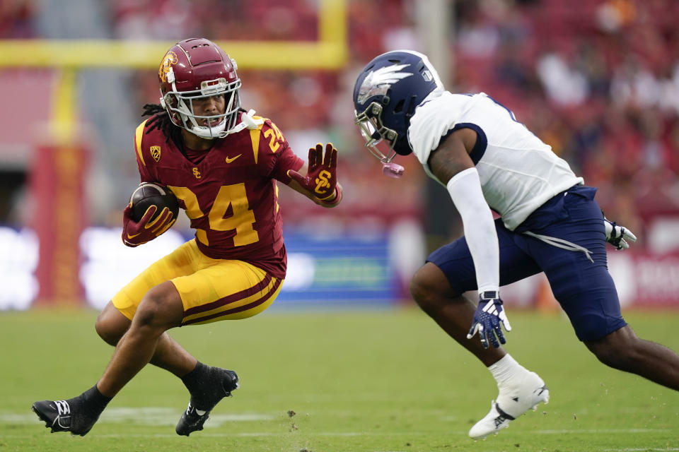 Southern California wide receiver Makai Lemon (24) prepares to stiff-arm Nevada defensive back Caine Savage, right, during the second half of an NCAA college football game, Saturday, Sept. 2, 2023, in Los Angeles. (AP Photo/Ryan Sun)