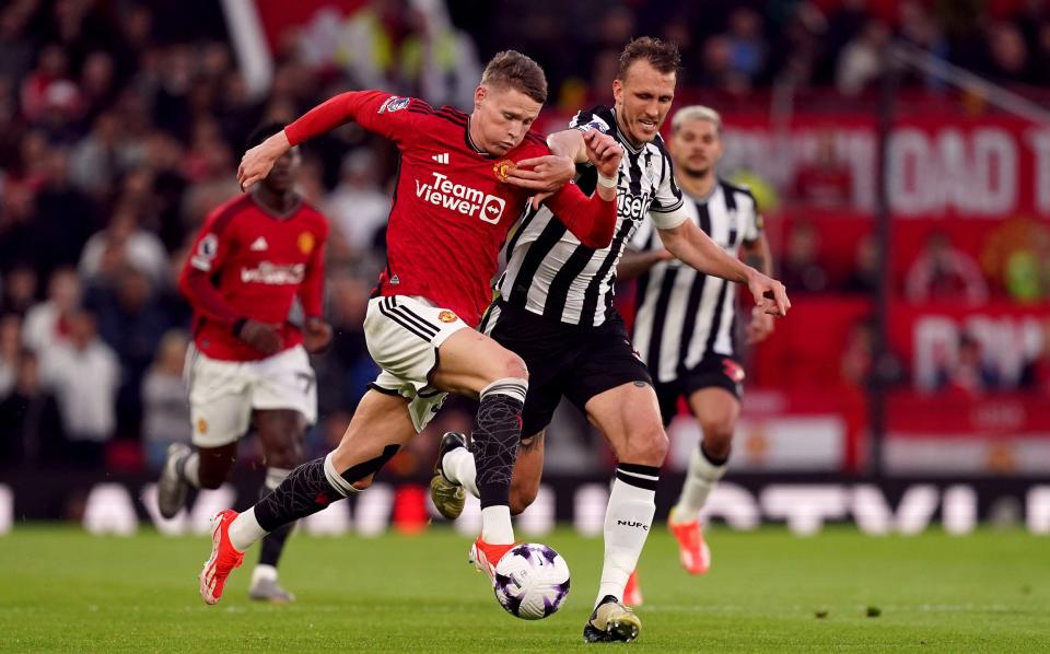 Scott McTominay and Dan Burn jostle for the ball