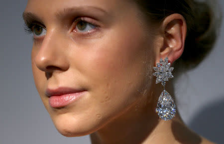 An assistant wears the Miroir de l'Amour, a pair of flawless diamond pear-shaped earrings during a sale preview at Christie's auction house in London, Britain October 20, 2016. REUTERS/Neil Hall/File Photo