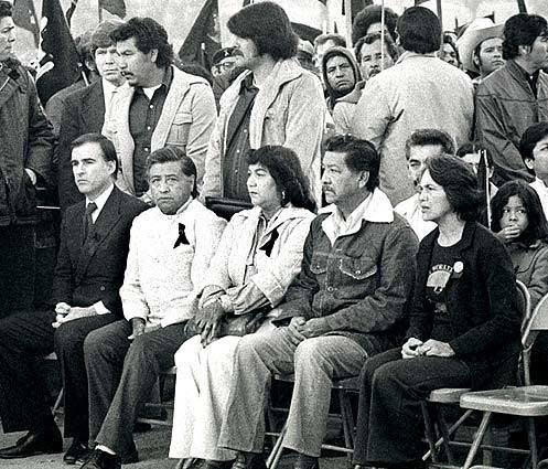 Brown, left, sits next to UFW leader Cesar Chavez at the graveside service for slain farmworker Rufino Contreras.