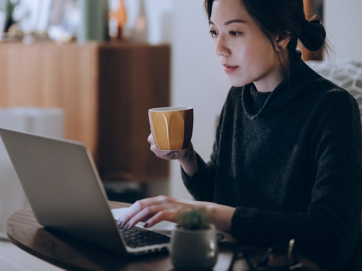 woman sitting at laptop with coffee mug