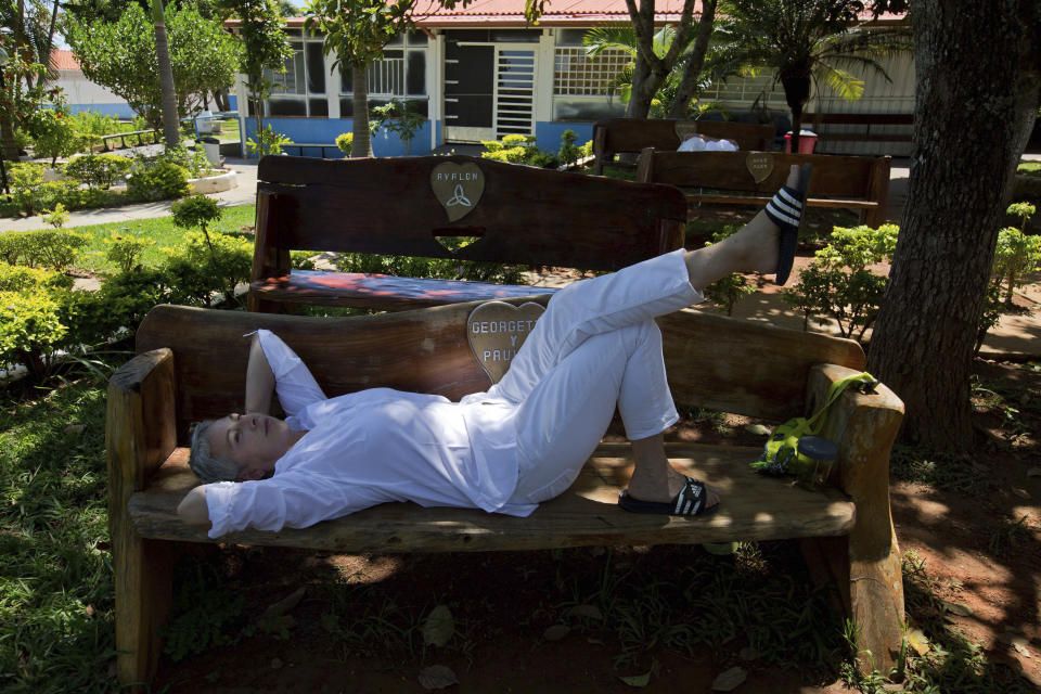 In this Jan. 3, 2019 photo, Tammy Pennington of the U.S., relaxes on a bench in the gardens of the Casa de Dom Inacio founded by spiritual healer Joao Teixeira de Faria, in Abadiania, Brazil. By all accounts, the number of visitors is way down, but the flow hasn't stopped entirely, since the arrest of the Brazilian spiritual healer who has been accused of sexual abuse by more than 250 women including his daughter. (AP Photo/Eraldo Peres)