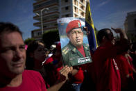 A woman holds a poster with the image of Venezuela's late president Hugo Chavez and a message that reads in Spanish; "Eternal Commander," marking the first anniversary of his death during an event in Havana, Cuba, Wednesday, March 5, 2014. (AP Photo/Ramon Espinosa)