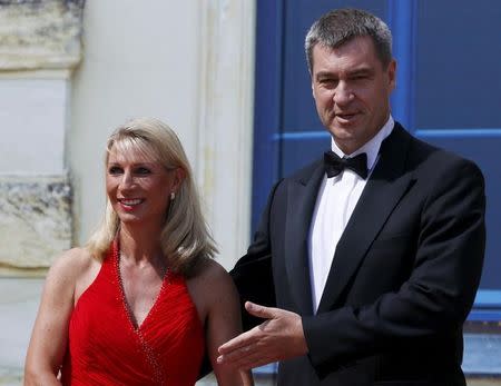 Bavarian Finance Minister Markus Soeder (R) arrives with his wife Karin on the red carpet for the opening of the Bayreuth Wagner opera festival outside the Gruener Huegel (Green Hill) opera house in Bayreuth, Germany, July 25, 2015. REUTERS/Ralph Orlowski