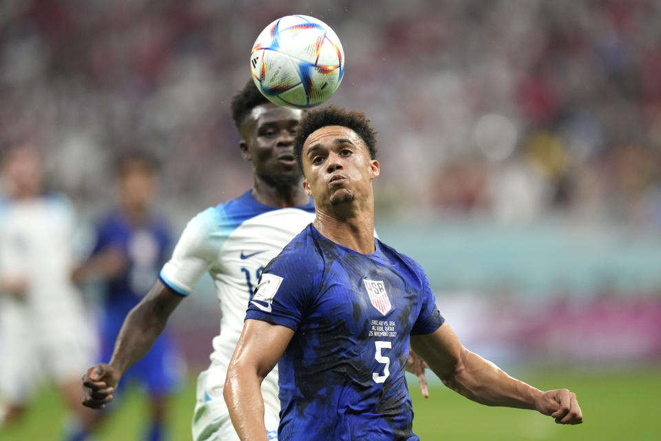 Antonee Robinson of the United States, right, challenges for the ball with England's Bukayo Saka during the World Cup group B soccer match between England and The United States, at the Al Bayt Stadium in Al Khor, Qatar, Friday, Nov. 25, 2022. (AP Photo/Andre Penner)