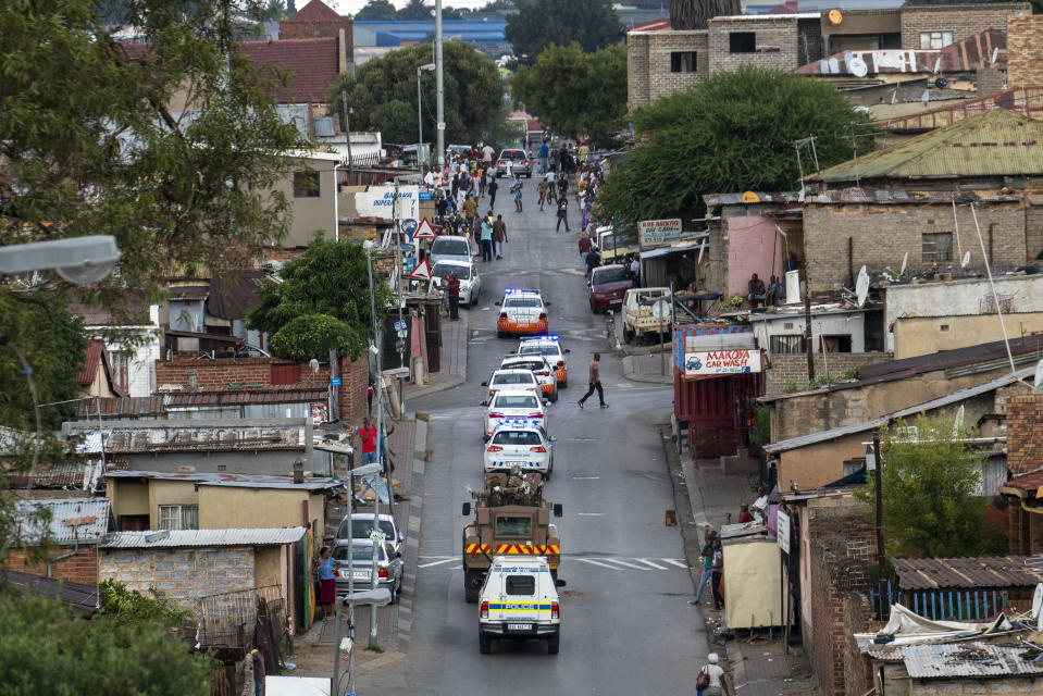 South African National Defense Forces and Police patrol the densely populated Alexandra township east of Johannesburg Friday, March 27, 2020. South Africa went into a nationwide lockdown for 21 days in an effort to mitigate the spread to the coronavirus, but in Alexandra, many people were gathering in the streets disregarding the lockdown. The new coronavirus causes mild or moderate symptoms for most people, but for some, especially older adults and people with existing health problems, it can cause more severe illness or death.(AP Photo/Jerome Delay)