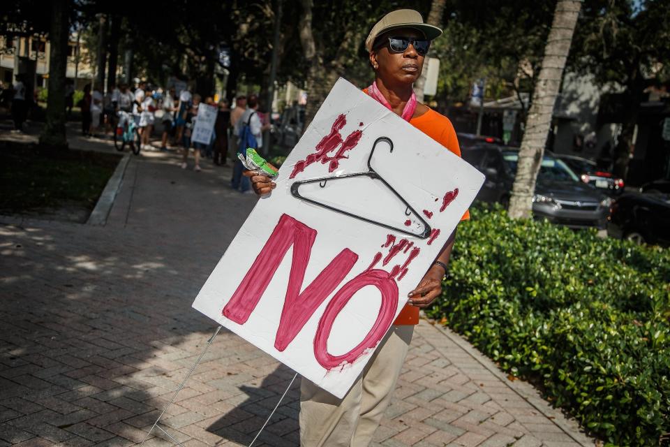 A protester in downtown Delray Beach carries a sign outside Old School Square following the U.S. Supreme Court's Roe v. Wade reversal on June 24, 2022.