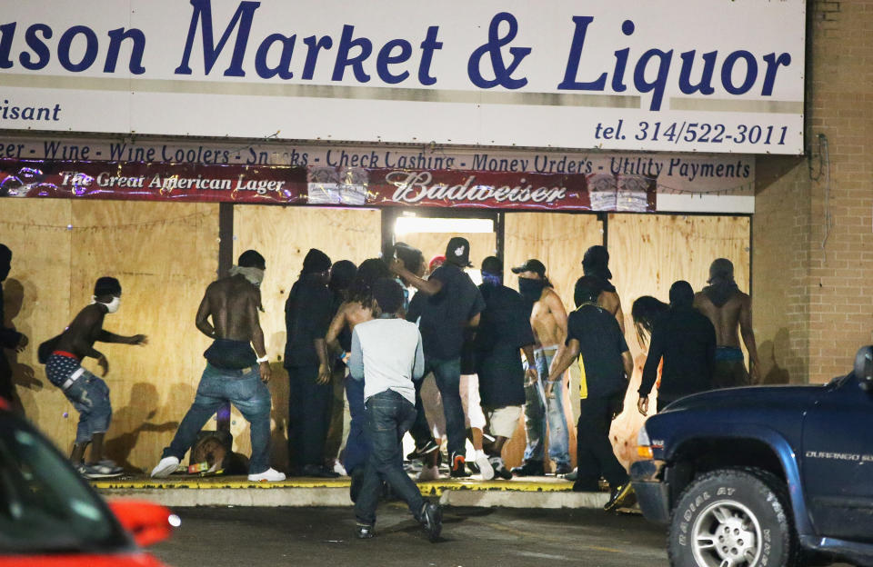 <p>People loot the Ferguson Market and Liquor store on August 16, 2014 in Ferguson, Missouri. Several businesses were looted as police held their position nearby. Violent outbreaks have taken place almost daily in Ferguson since the shooting of Michael Brown by a Ferguson police officer on August 9. (Scott Olson/Getty Images) </p>