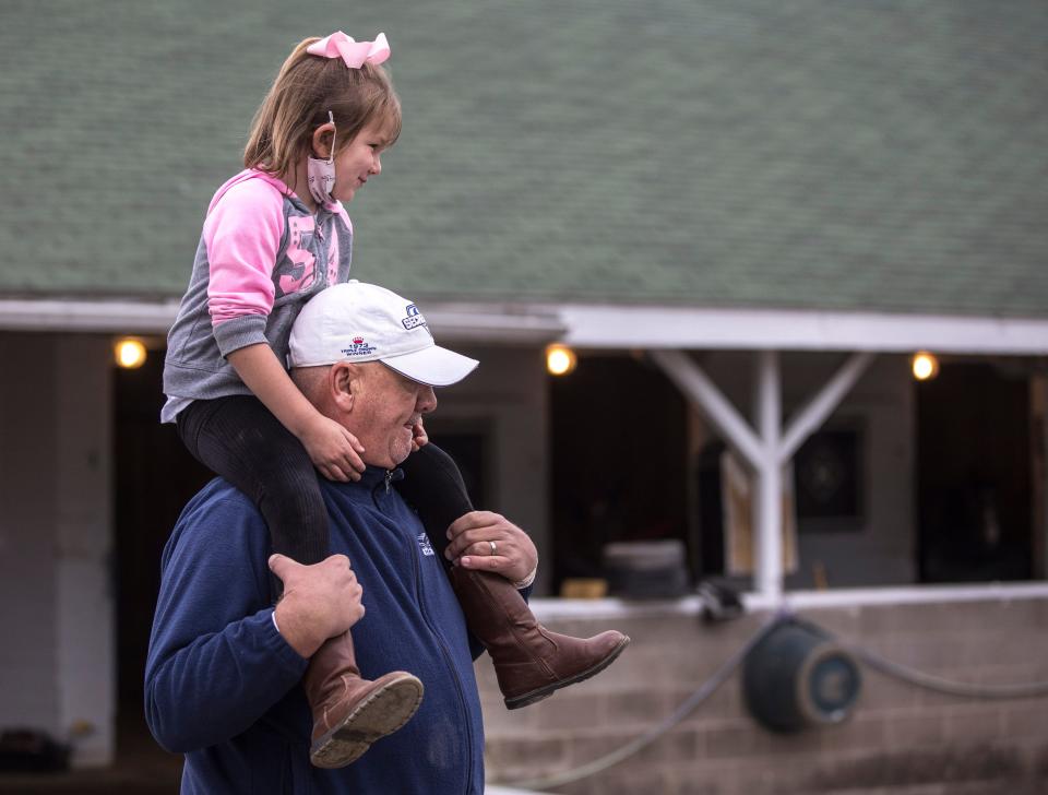 Kenny McPeek, trainer of Kentucky Oaks entrant Crazy Beautiful and Kentucky Derby starter King Fury cries his daughter Annie, 5, on his shoulders on the backside of Churchill Downs. April 24, 2021