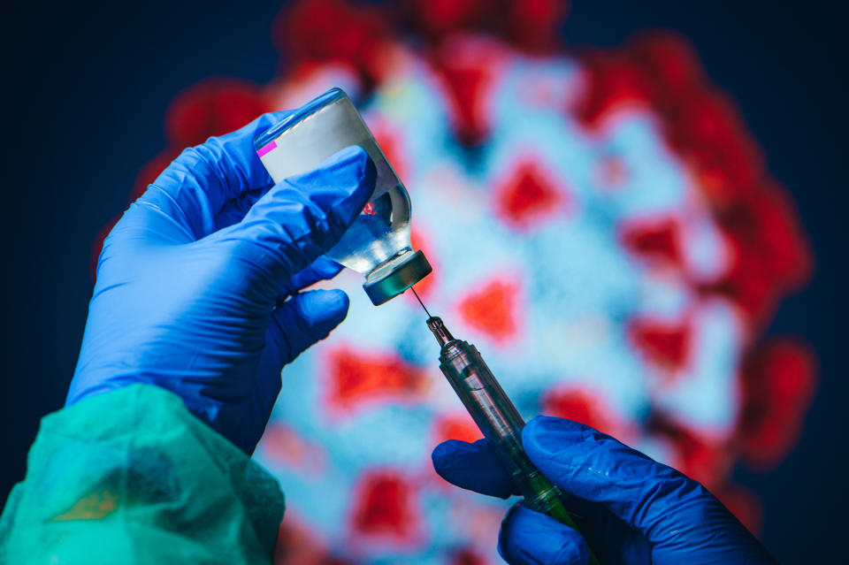 Coronavirus Covid-19 Protection and Vaccine. Doctor drawing up solution from vaccine bottle and filling syringe injection for patient vaccination in medical clinic, Coronavirus in background