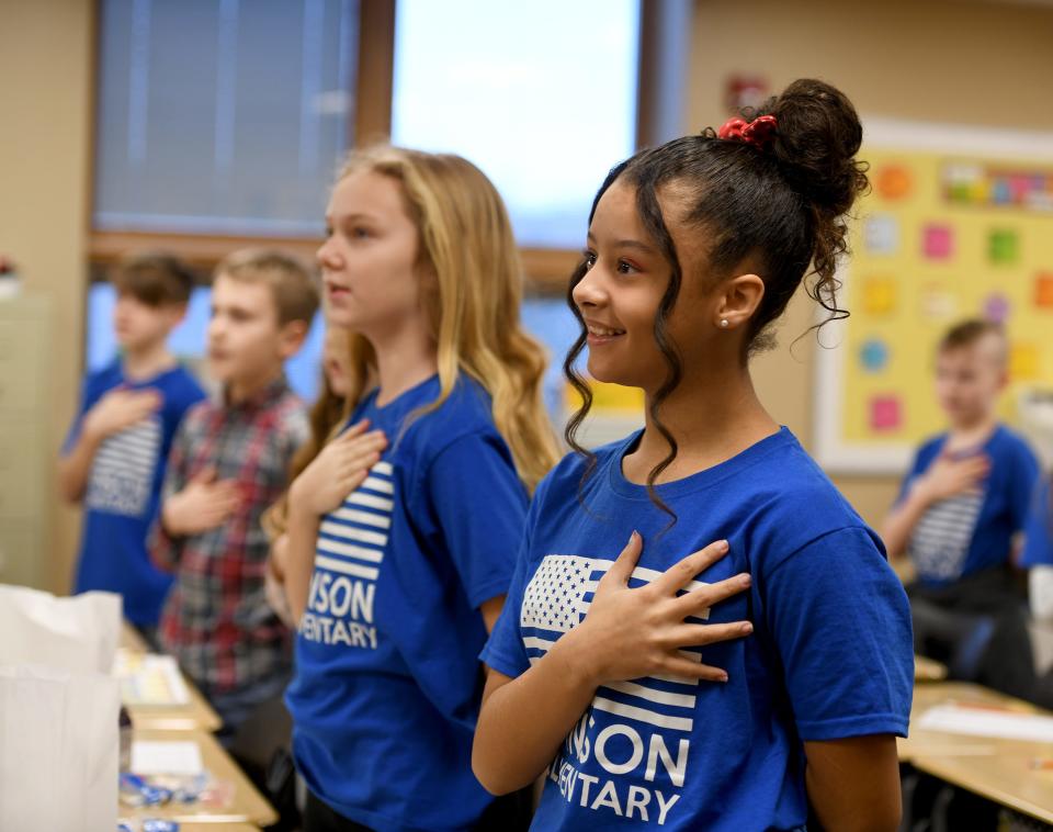 Students, including Caleigh Brasiel, right, recite the Pledge of Allegiance in Lisa Baldwin's fourth grade class at Northwest's W.S. Stinson Elementary School.