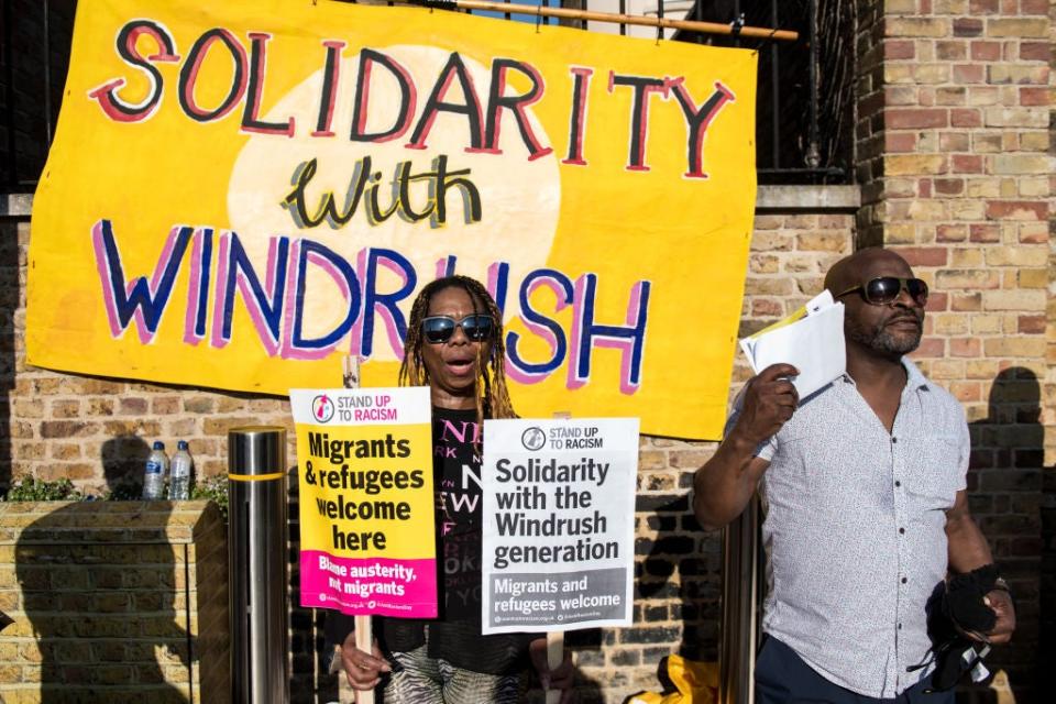 Protesters in Brixton hold signs in support of those affected by the Windrush scandalGetty