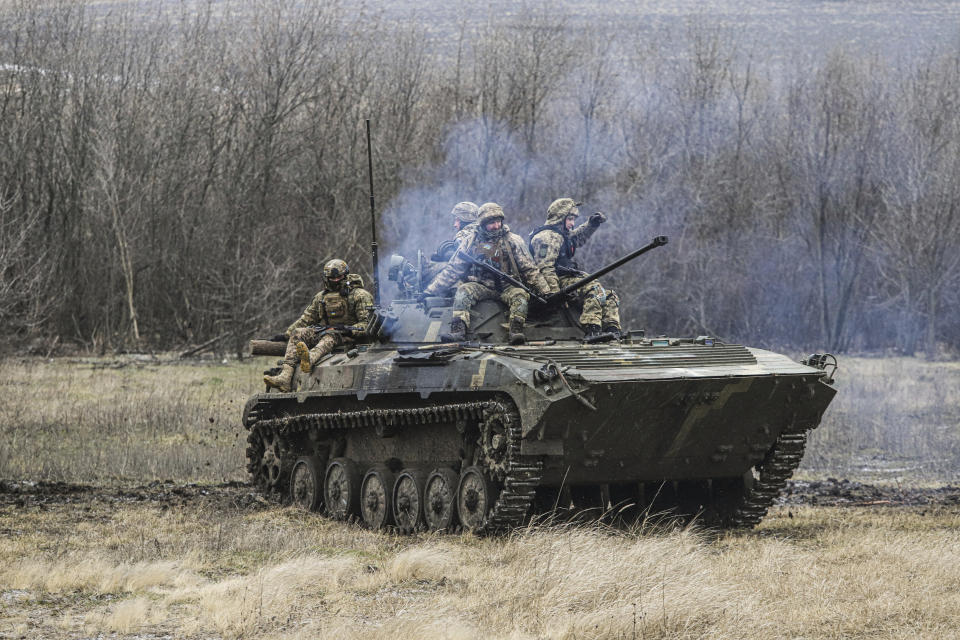 Ukrainian soldiers sit on top of an APC during combat training in Zaporizhzhia region, Ukraine, Tuesday, Jan. 24, 2023. (AP Photo/Kateryna Klochko)