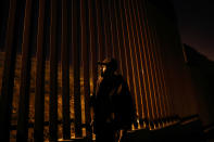 FILE- Armando Mayorga, originally from Nicaragua, but deported from the United States after living in California for years, looks towards the United States through the newly replaced border structure Wednesday, Jan. 9, 2019, in Tijuana, Mexico. Top Trump administration officials will visit South Texas five days before Election Day to announce they have completed 400 miles of U.S.-Mexico border wall, attempting to show progress on perhaps the president's best-known campaign promise four years ago. But most of the wall went up in areas that already had smaller barriers. (AP Photo/Gregory Bull)