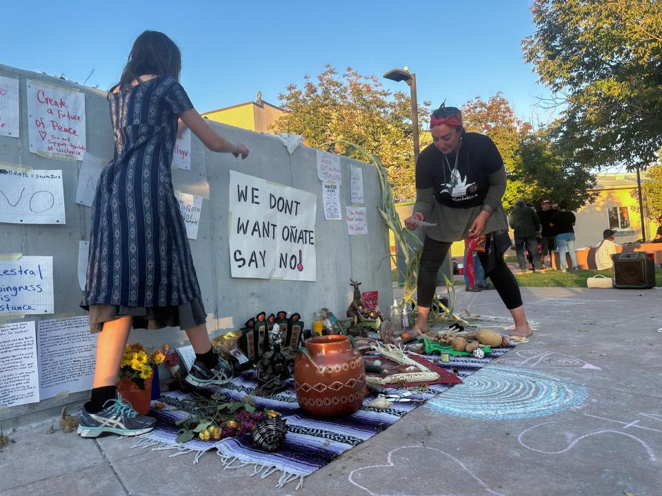 Ixchel Topete and her mother Soula Topete arrange an altar in front of a concrete platform where authorities had planned to reinstall a statue of conquistador Juan de Onate but postponed the event after protests, at the Rio Arriba County Complex in Espanola (Reuters)