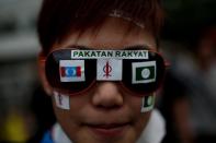 A young Malaysian opposition supporter displays the party's logo on her sunglasses as supporters gather at a stadium in Kelana Jaya, Selangor on May 8, 2013. Thousands of Malaysians dressed in mourning black gathered Wednesday to denounce elections which they claim were stolen through fraud by the coalition that has ruled for 56 years