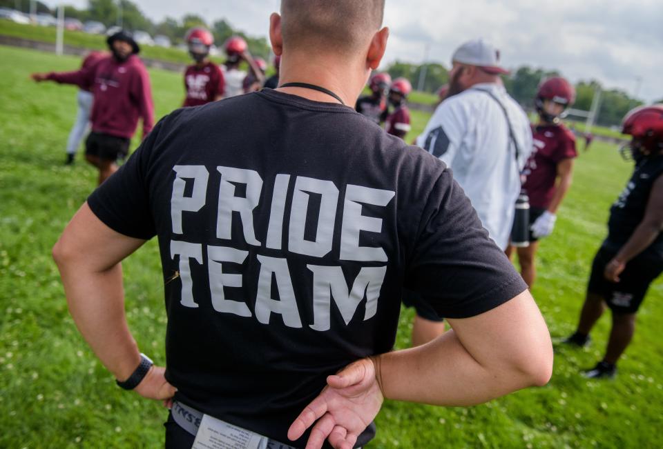 An assistant coach sports an inspirational message on his shirt during the official first day of high school football practice Monday, Aug. 7, 2023 at Peoria High School.