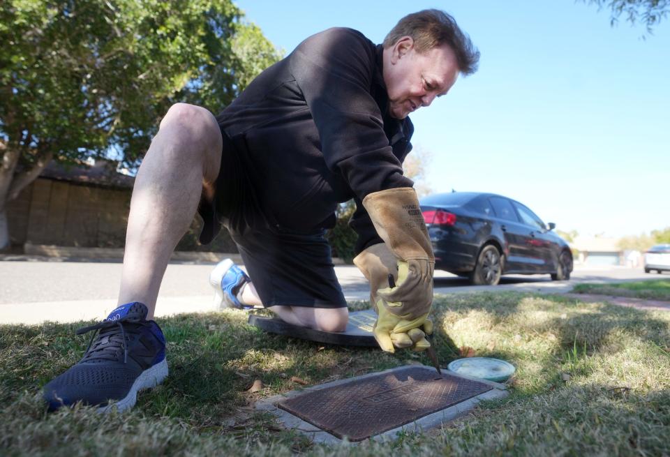 Ken Hoag inspects a recently installed water meter outside his north Phoenix home Feb. 16, 2024. At the end of 2023, Hoag received notice that a pipe burst under his home losing 160,000 gallons to an in-yard leak, and that he would be charged for a water bill nearly 20 times his average monthly payment.