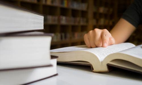 Woman reading book in library