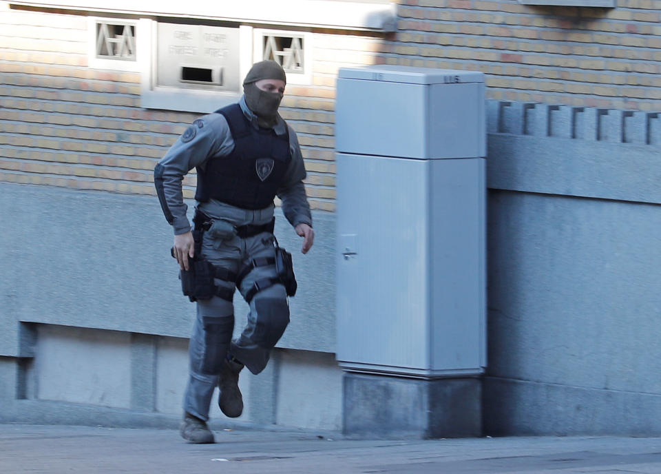 A Belgian police special forces member runs through the Forest region (Reuters)