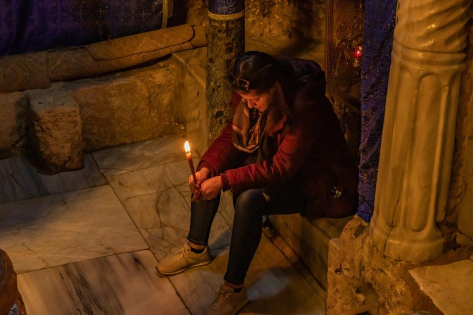 A worshipper prays for peace at the grotto inside the Church of the Nativity (Bel Trew/The Independent)