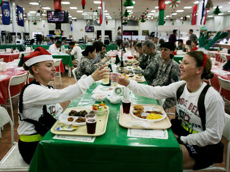 U.S. Air Force Majors Marla Ferguson, from Whitehouse, Ohio, left, and Dorothy DeLeon, from Greenville, N.C., right, toast glasses of sparkling cider for Christmas at the military dining hall at Camp Victory on the outskirts of Baghdad, Iraq, Friday, Dec. 25, 2009.